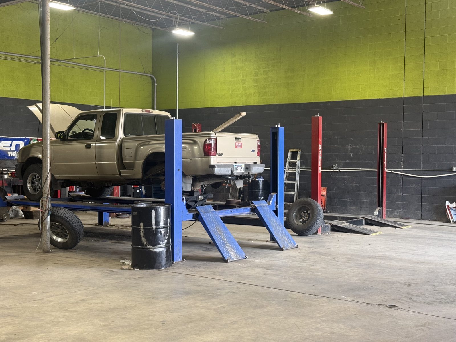 Vehicles up on the lifts at Harrison Battery & Tire